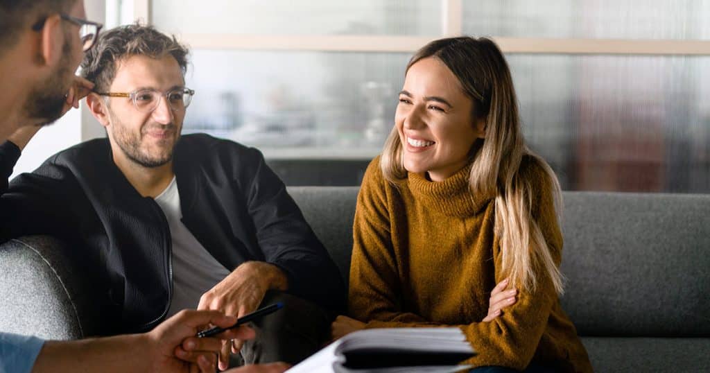 Couple of professionals smiling during informal meeting