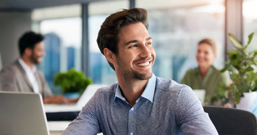 Male professional smiling at office desk